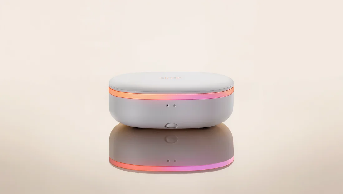 The Glimpse device — a small white rounded hub with a soft coral indicator light